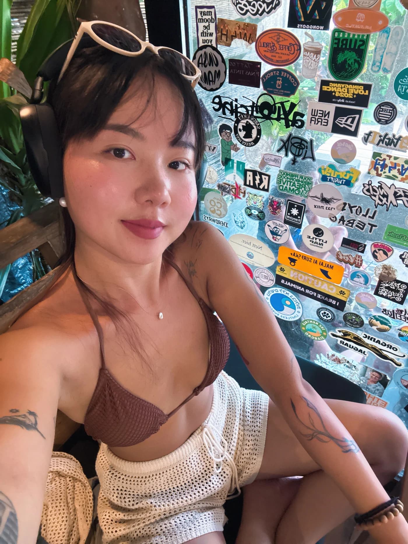 栗子戴着耳机的近照，双臂上是她的纹身
